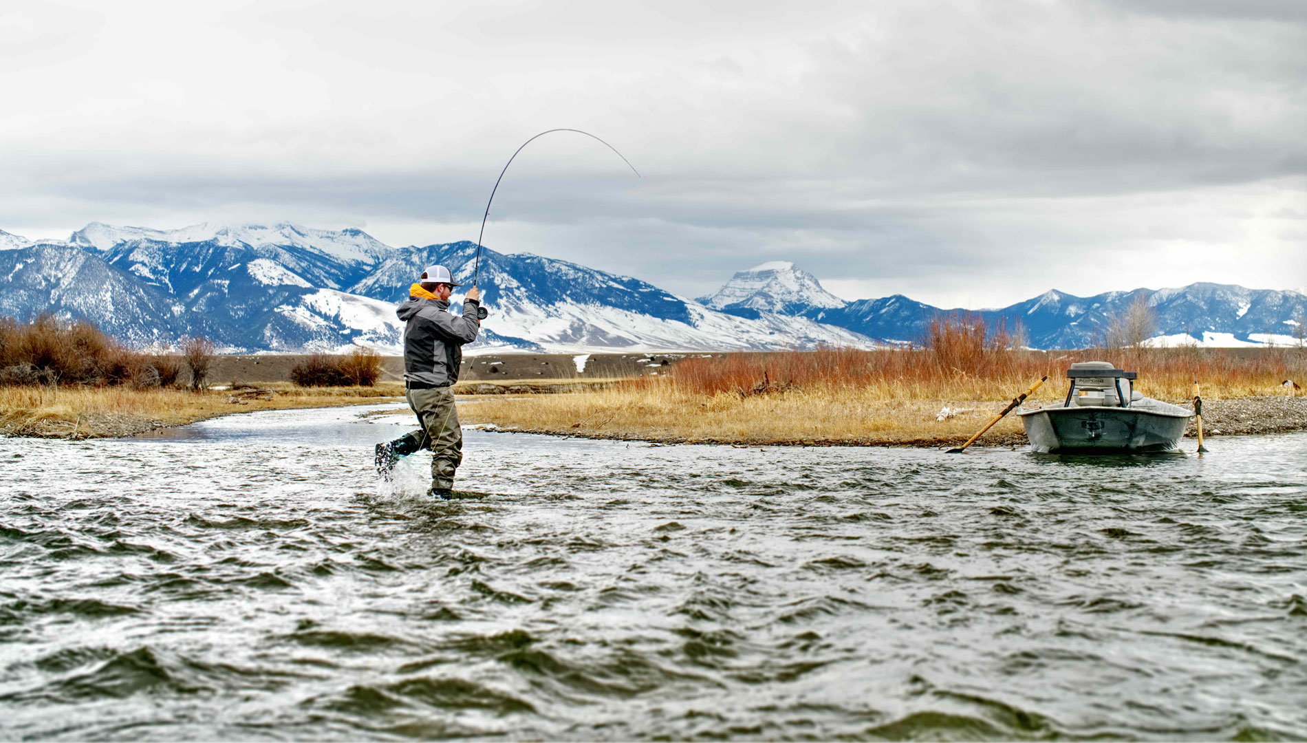 fly fisherman has a fish on along madison river